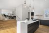 Modern black kitchen with white marble counter tops textured tiles styled to sell