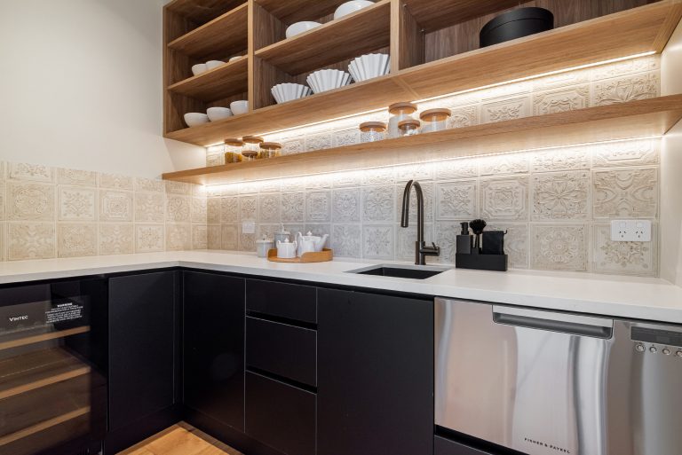 Butlers pantry with Black cupboards and light oak open shelving cream textured tiles staged to sell