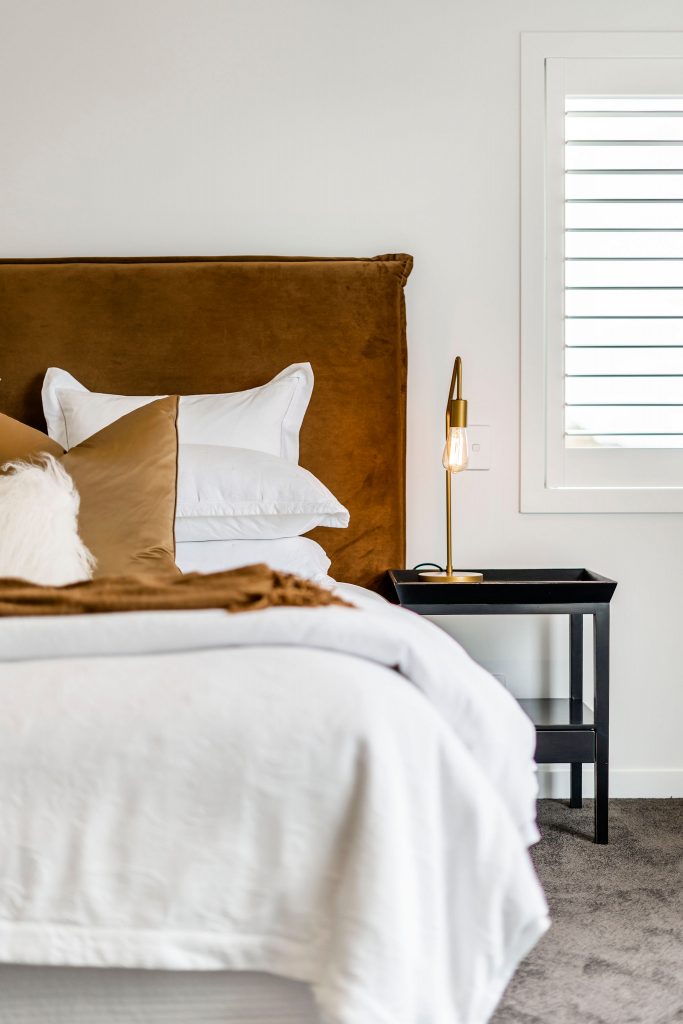 Master Bed, primary bed, Velvet headboard in rust, Gold lamps Luxury bedding